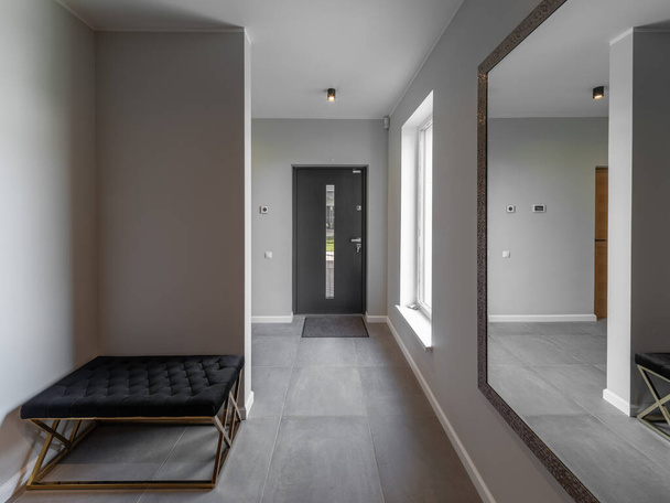 Modern interior of luxury apartment. Private house. Entrance hall. Mirror on wall. Tile floor. - 写真・画像