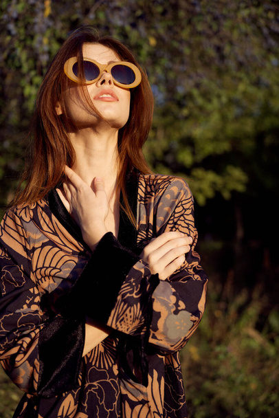 pretty woman wearing sunglasses outdoors fashion nature - Foto, afbeelding