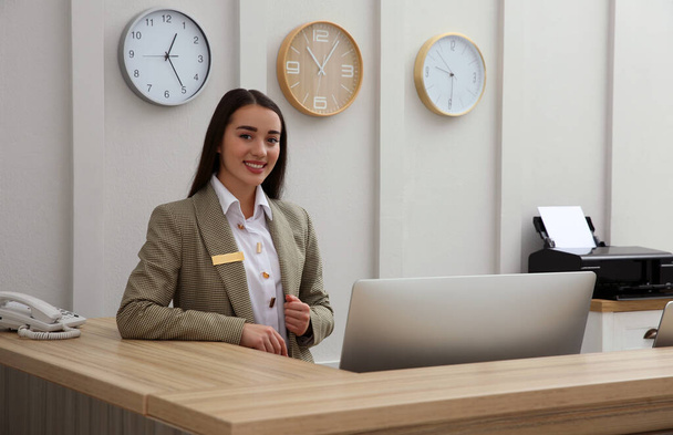 Portrait of beautiful receptionist at counter in hotel - Photo, Image