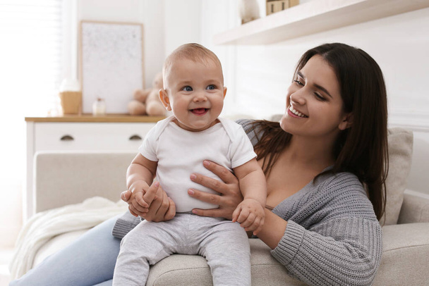 Happy young mother with her cute baby in living room - Photo, Image