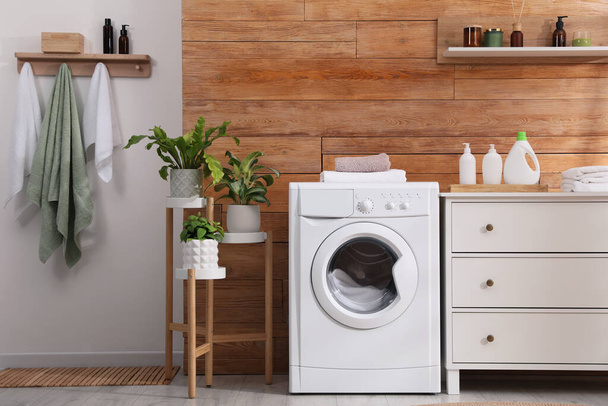 Laundry room interior with washing machine and stylish furniture - Foto, Imagen
