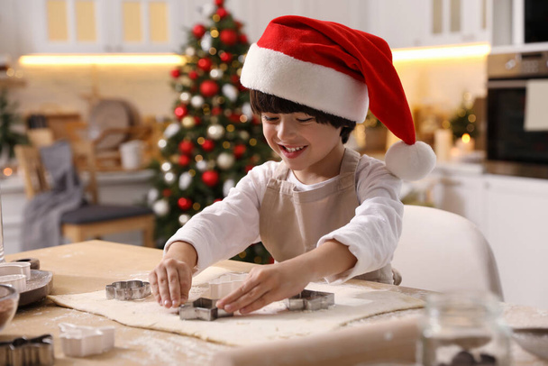 Cute little boy making Christmas cookies in kitchen - Valokuva, kuva