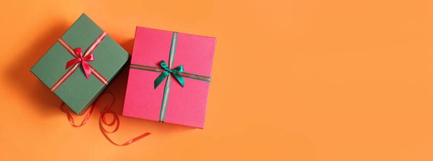 Красивые рождественские подарки на оранжевом фоне с местом для текста - Фото, изображение