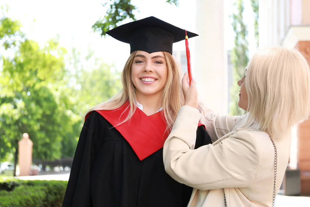 Happy young woman with her mother on graduation day - Photo, Image