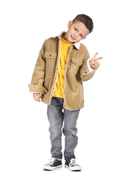Portrait of cute little boy showing victory gesture on white background - Foto, imagen