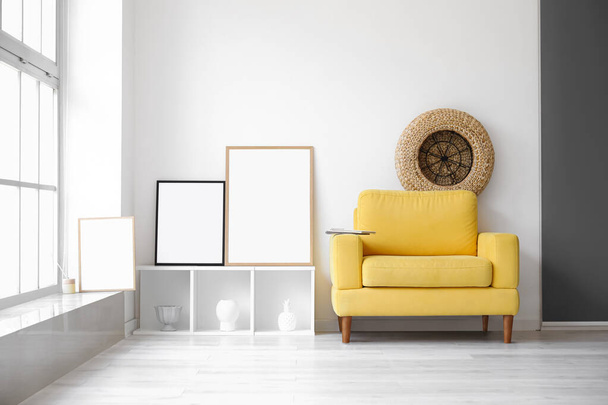 Molduras em branco na prateleira e poltrona amarela na sala de estar clara - Foto, Imagem