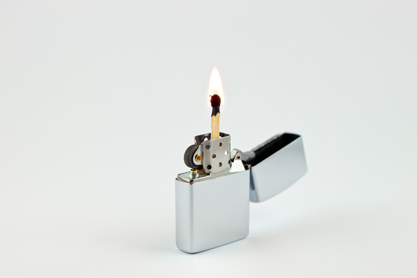 Lighted up match on a shiny lighter - Fotoğraf, Görsel