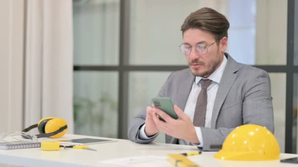 Keskiaikainen insinööri puhuu puhelimessa toimistossa  - Materiaali, video