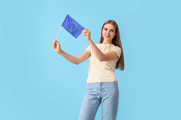 Όμορφη νεαρή γυναίκα με σημαία της Ευρωπαϊκής Ένωσης σε μπλε φόντο - Φωτογραφία, εικόνα