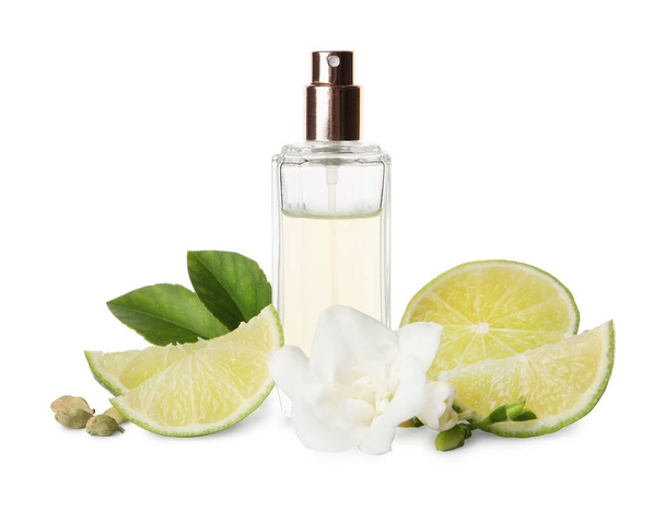 Bottle of perfume, lime, flower and cardamom on white background - Photo, Image