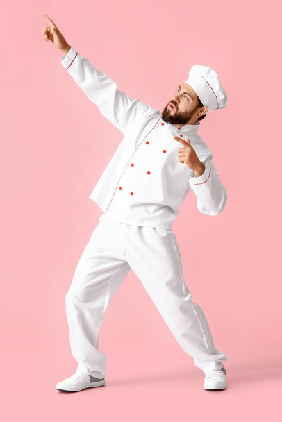 Dancing male chef on pink background - Foto, Imagen