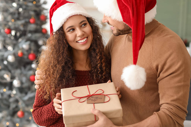Happy couple with Christmas gift at home - Photo, Image