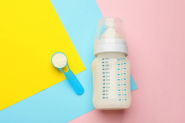 Feeding bottle with infant formula and powder on color background, flat lay - Fotografie, Obrázek