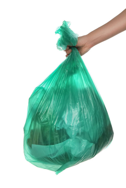 Woman holding trash bag filled with garbage on white background, closeup - Photo, image