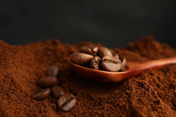 Coffee grounds and roasted beans on dark background, closeup - Фото, зображення