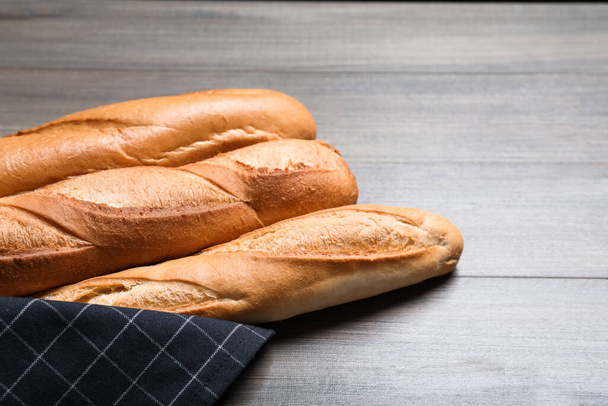 Tasty baguettes on wooden table, closeup. Space for text - Foto, Bild