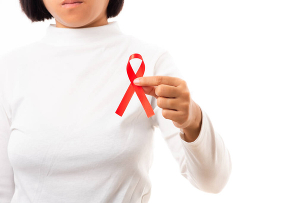 Woman holding HIV AIDS awareness red ribbon in studio shot isolated on over white background, Healthcare and medicine, World aids day concept - Foto, Imagem