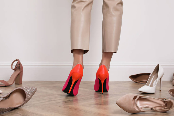 Woman trying on different shoes indoors, closeup - Fotó, kép