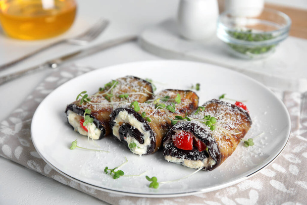 Delicious baked eggplant rolls served on white table - Foto, afbeelding