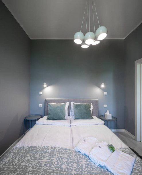 Interior contemporâneo do quarto em cores cinza. Apartamento moderno. Vista frontal da cama queen size. - Foto, Imagem