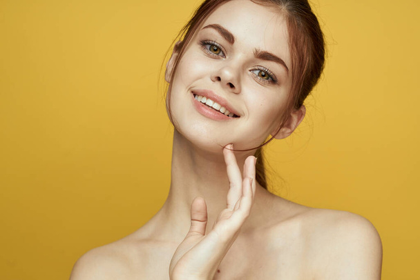 woman with bare shoulders clean skin hairstyle posing yellow background - Zdjęcie, obraz