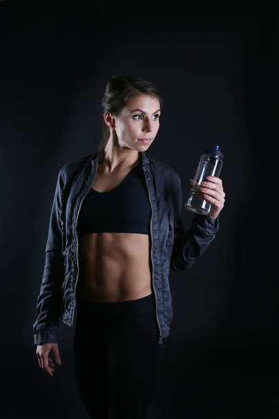 Спортивная женщина с бутылкой в руках
 - Фото, изображение