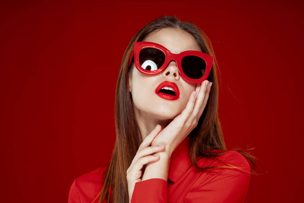 beautiful woman wearing sunglasses red shirt makeup isolated background - Photo, Image