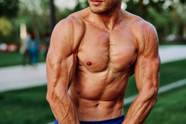 man with pumped up muscular body outdoors health workout - Foto, Bild