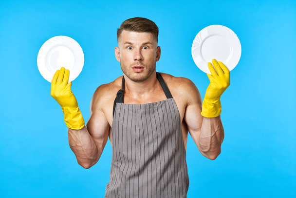 Cheerful man in aprons washing dishes housework blue background - Foto, Imagem