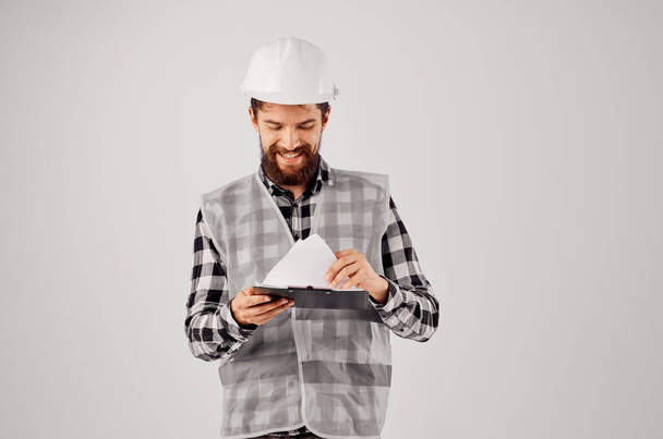 male worker in a white helmet blueprints Professional isolated background - Photo, Image