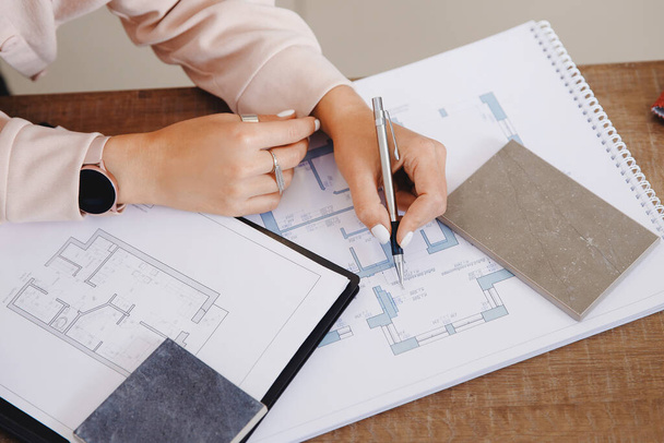 Профессиональный архитектор и дизайнер интерьера, работающий на рабочем месте, рисует план квартиры на ноутбуке - Фото, изображение