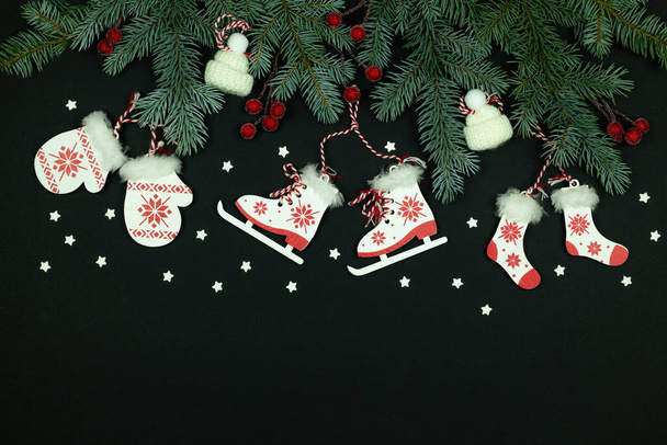 Frohe Weihnachten und einen guten Rutsch ins neue Jahr Hintergrund. Weihnachtsbaum auf schwarzem Hintergrund. Komposition aus Weihnachtsbaumschmuck aus Holz und Schneeflocken - Foto, Bild