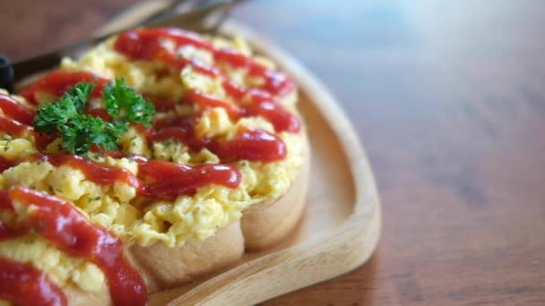 Panning shot of scrambled eggs on toasted bread with ketchup, breakfast in morning at home. - Footage, Video