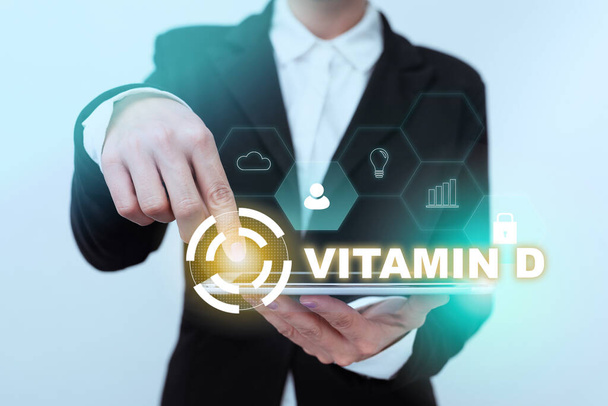 Text caption presenting Vitamin D. Business idea Nutrient responsible for increasing intestinal absorption Lady In Suit Pointing On Tablet Showing Futuristic Graphic Interface. - Photo, Image