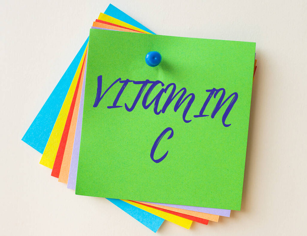 Texto conceptual Vitamina C. Palabra para que promueve la curación y ayuda al cuerpo a absorber el hierro Ácido ascórbico Notas de papel coloridas apiladas juntas y fijadas en la pared. - Foto, imagen