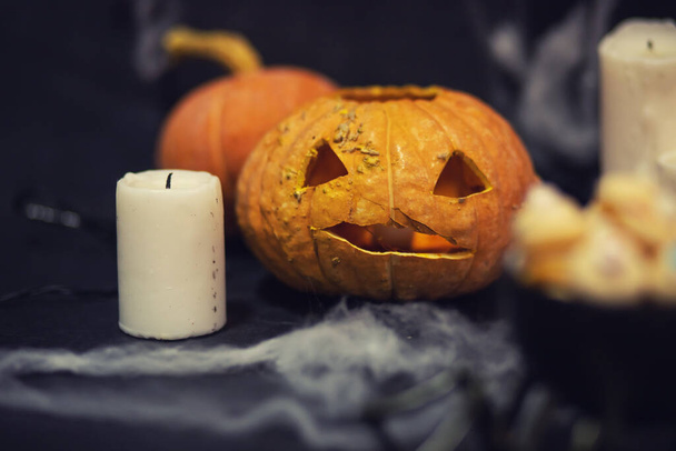 Halloween Donkere achtergrond met pompoenkop, spinnenwebben en kaarsen - Foto, afbeelding