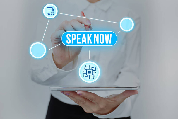 Text sign showing Speak Now. Business approach Communicate to us your feelings and information Voice out Lady In Uniform Standing Holding Tablet Typing Futuristic Technologies. - Photo, Image