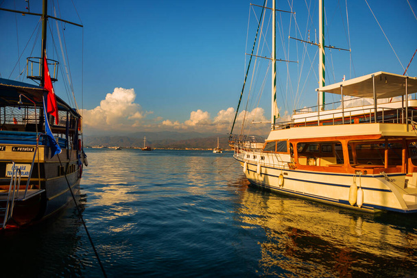 FETHIYE, TURKEY: View of the harbor with numerous yachts, and beautiful mountains in the background in the rays of the sun - Zdjęcie, obraz