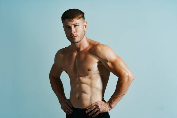 bodybuilder with muscular body posing press blue background - Foto, Bild