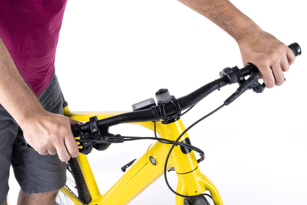 Mãos masculinas irreconhecíveis segurando o guidão de uma bicicleta, isolado em um fundo branco, vista close-up. - Foto, Imagem