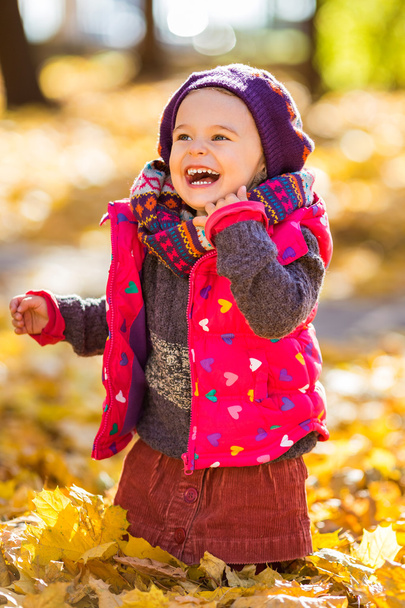 Happy little girl playing in the autumn park - Zdjęcie, obraz