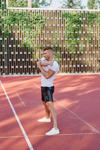 athletic men doing exercises on the sports ground in summer - Photo, image