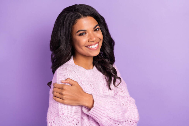 Photo of shiny cute dark skin woman wear pink sweater smiling embracing herself isolated violet color background - Foto, Bild