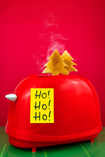 Kırmızı tost makinesi taze kızarmış ekmek köknar ağacı şekilli yeşil fayans. Kahvaltılık yemek. Sabah sandviçi, yaratıcı minimalizm fikri Ho Ho Ho sarı çıkartması. Noel İndirimi Mutfak Aletleri - Fotoğraf, Görsel