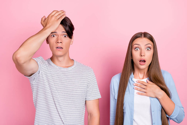 Photo of cute shocked upset young lovers dressed casual outfits arm chin chest isolated pink color background - Foto, Imagen