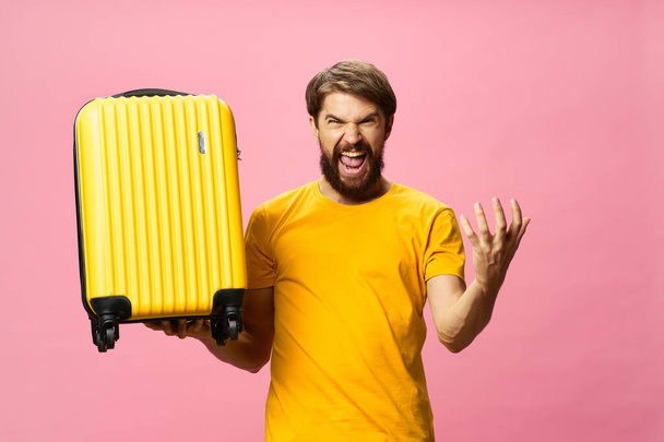 hurlement homme avec valise passager aéroport rose fond - Photo, image