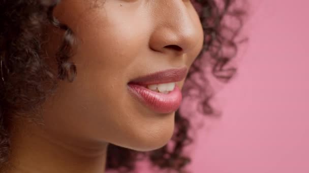 Крупный план афроамериканской леди улыбается на фоне розовой студии - Кадры, видео