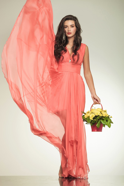 Dame mit flatterndem rotem Kleid mit einem Blumenkorb - Foto, Bild