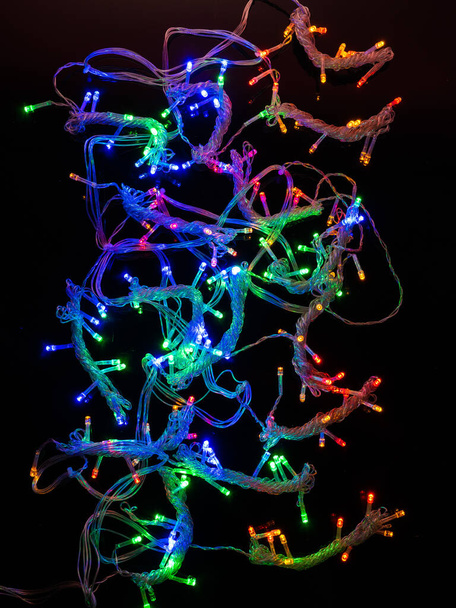 multicolored garland with small led bulbs on a dark background - Fotografie, Obrázek