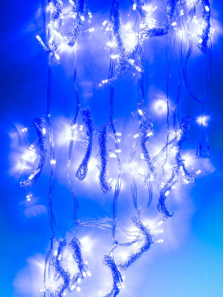 bunte Girlande mit kleinen LED-Lampen auf dunklem Hintergrund - Foto, Bild